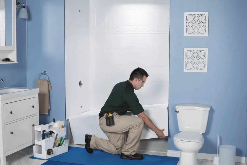 man installing a bathub for a budget-friendly bathroom remodel with Bath Fitter